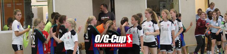Jugendliche Handballspielerinnen geben sich die Hand nach einem Spiel in einer Halle