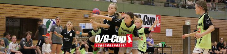 Jugendliche Spielerinnen beim Handballspiel in einer Halle mit Zuschauern im Hintergrund