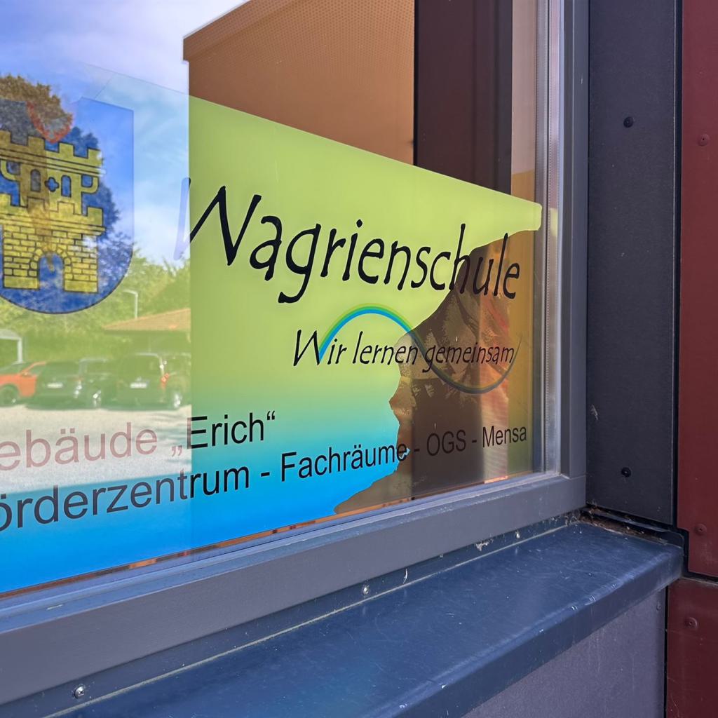 Fensterscheibe mit Aufschrift Wagrienschule und Wappen reflektierend